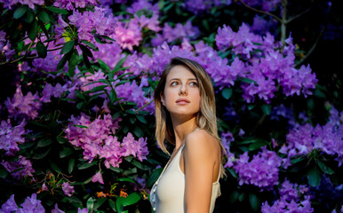 Poster - style woman near rhododendron flowers in a grarden in spring time