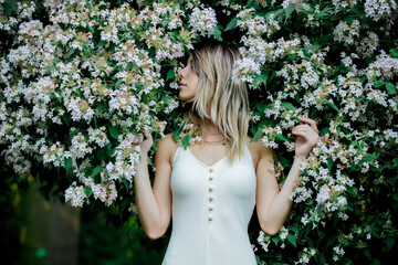 style woman near blooming tree in a grarden in spring time