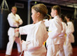 Children wearing karate uniform fighters poses in white kimono, group training
