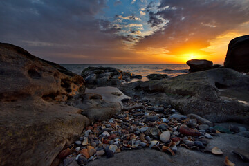 Sticker - Russia. Dagestan. Dawn on the rocky shore of the Caspian Sea, strewn with many shells, near the city embankment of the city of Makhachkala.