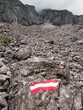 Mure in den Alpen bei Gramais Richtung Branntweinboden mit der Nationalflagge Österreichs als Wandersymbol auf einem Stein
