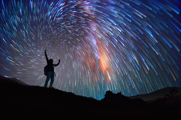 Wall Mural - Landscape with Milky Way. Night sky with stars and silhouette of a standing happy man on the mountain, Success or winner, leader concept.  