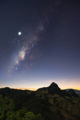 Wall Mural - Milky Way galaxy with stars at night in mountain forest and sunrise.