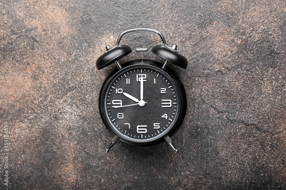 Stylish alarm clock on grunge background