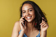 © Drobot Dean - Young hispanic woman smiling while talking on mobile phone
