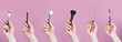 © iso100production - Set of makeup brushes in female hand isolated on pink background