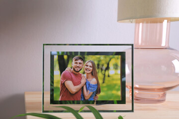 Sticker - Frame with photo of young couple on wooden table indoors