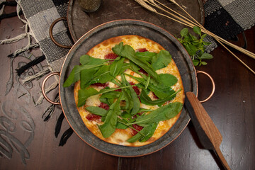 Brazilian pizza with sun-dried tomatoes, arugula and mozzarella