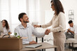© New Africa - Boss shaking hand with new coworker in office