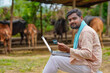 © Niks Ads - Young indian farmer using laptop and card at his farm