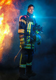 Fototapeta Sport - Feuerwehrmann steht vor Flammen und Blaulicht