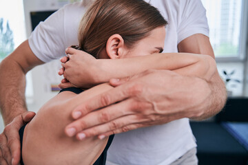 Unrecognized man acupressure specialist examining back pain in medical office