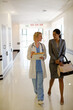 © KOTO - Doctor and businesswoman walking in hospital corridor