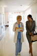 © KOTO - Doctor and businesswoman walking in hospital corridor