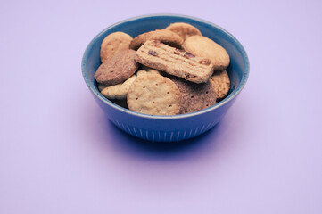 Poster - A vertical shot of biscuits in a bowl on a mauvebackground