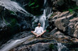 © ADDICTIVE STOCK - Serene man meditating in Lotus pose near waterfall