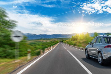 Grey car on a scenic road. Car on the road surrounded by a magnificent natural landscape.