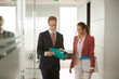 © KOTO - Business people talking in office hallway