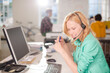© KOTO - Businesswoman talking on headset at desk