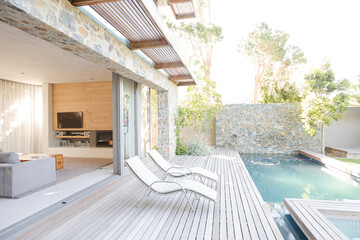 Lawn chairs and swimming pool in backyard