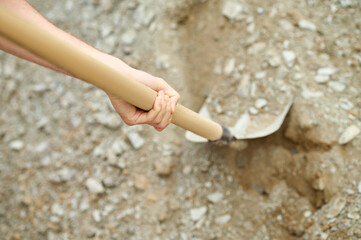 Poster - Hand of an experienced builder digging ground using a spade