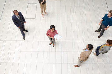 Canvas Print - Businesswoman standing in busy office hallway