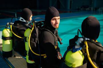 Wall Mural - Divemaster and two divers preparing for the dive