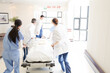 © KOTO - Doctors rushing patient on gurney in hospital corridor