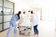 © KOTO - Doctors rushing patient on gurney in hospital corridor