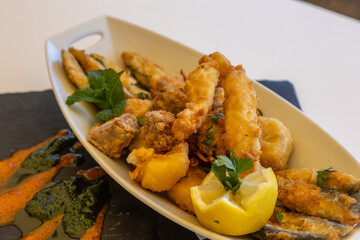 Poster - Closeup shot of fried shrimps and fish decorated with lemon and mint on the serving plate