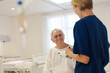 © KOTO - Nurse and older patient talking in hospital room