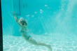 © KOTO - Woman swimming underwater in  pool