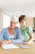 © KOTO - Older woman and granddaughter using calculator