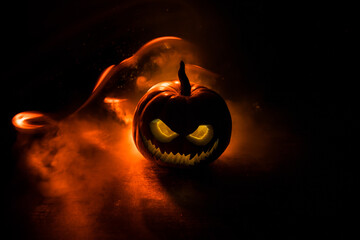 Halloween pumpkin smile and scary eyes for party night. Close up view of scary Halloween pumpkin with eyes glowing inside at black background