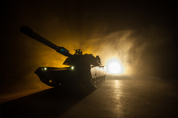 Wall Mural - War Concept. Armored vehicle silhouette fighting scene on war foggy sky background at night. American tank ready to fight.