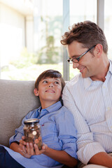 Father and son holding change jar