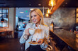 © Dusan Petkovic - The happy catchy blonde lady sitting in a cafe of the popular hotel and enjoying her afternoon coffee. Break, hot beverage