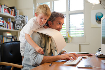 Boy hugging working father