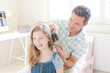 Father combing hair to his daughter