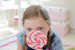 Girl licking lollipop in bedroom