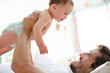© KOTO - Father playing with baby son on sofa