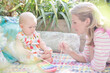 Mother and baby girl playing with xylophone outdoors