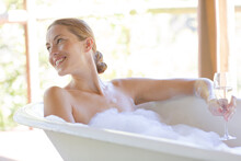 Woman Having Champagne In Bubble Bath