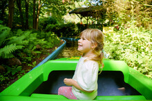 Adorable Little Toddler Girl Riding On Boat Carousel In Amusement Park. Happy Healthy Baby Child Having Fun Outdoors On Sunny Day. Family Weekend Or Vacations