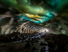 Snow Cave With A Multi-colored Ceiling With Yellow, Blue, Green, White Inserts, A Silhouette Of A Man And A River