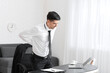 © Pixel-Shot - Young man suffering from back pain in office