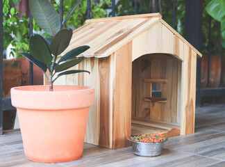 Wall Mural - wooden dog's house with dog food bowl  in balcony decorated with houseplant in plant pot.