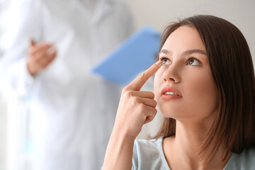 Wall Mural - Young woman putting in contact lenses at ophthalmologist's office