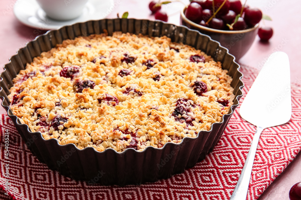 Baking dish with tasty cherry pie on color background, closeup