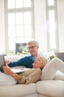 © KOTO - Older couple relaxing together on living room sofa